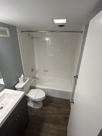 a bathroom with a toilet, shower, and sink