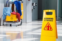 a yellow cleaning in progress sign in a hallway