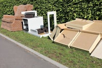 a pile of boxes and furniture on the side of the road