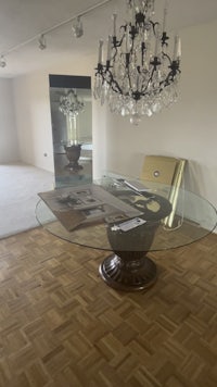 an empty room with a glass table and chandelier